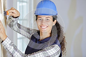 Female builder using wallpaper scraper