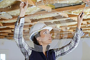 female builder working on ceiling