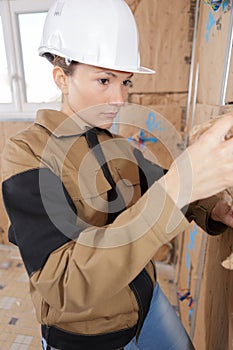 Female builder working on insulation wall