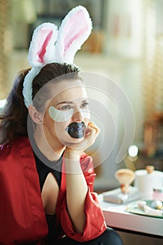 Female with bunny ears making cosmetic lip mask and eye mask