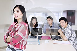 Female business leader folded hands near her team