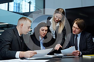 Female business leader writing on paper at meeting in office