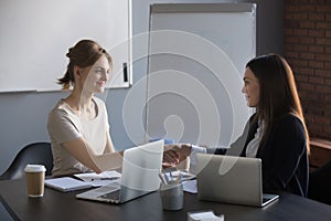 Female business partners handshaking after successful negotiatio