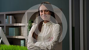 Female business portrait confident Caucasian businesswoman posing in office with hands crossed Caucasian girl smiling