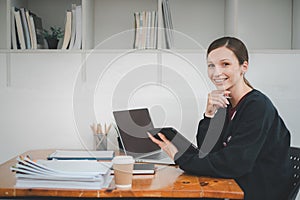 Female business woman using tablet and laptop for analyzing the business report