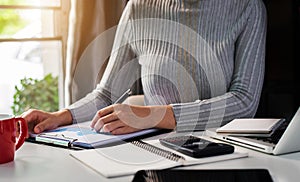 Female businessman calculates financials with graph paper on the laptop computer.