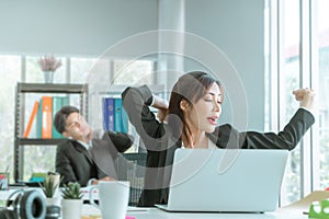 Female businesswoman worker is stretching and yawn in office workplace, after a long time of sleepy work
