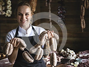 Female butcher selling sausages in shop