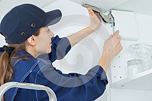 Female cabinet installer fixing door