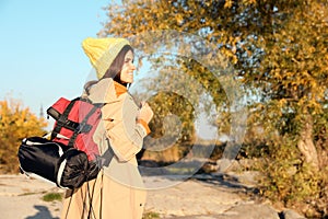 Female camper with backpack and sleeping bag in wilderness.