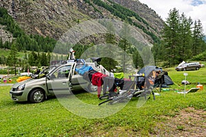 Female camper drying wet clothes after heavy storm in mountain camping.