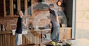 Female cancer patient celebrate remission dancing with husband in kitchen