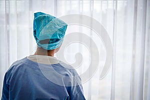 A female cancer patient sat sadly in bed, looking at the window.