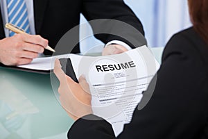 Female candidate holding resume at desk