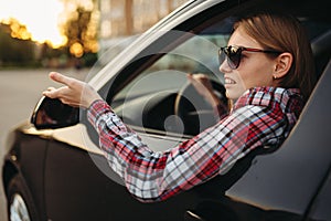 Female car driver in sunglasses, boorish behavior