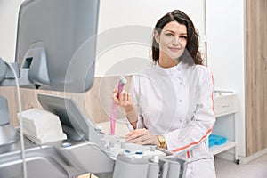 Female cardiologist using ultrasound scanner, looking at the camera