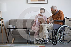 Female Caregiver Assisting Senior Man in Wheelchair