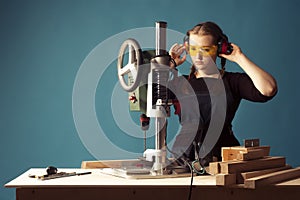 Female carpenter and drilling machine.