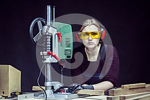 Female carpenter and drilling machine.