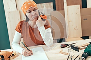 Female carpenter is drinking coffee and planning DIY project