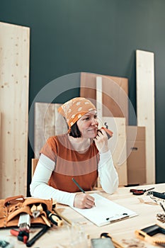 Female carpenter is drinking coffee and planning DIY project photo
