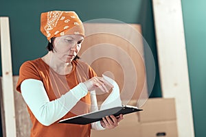 Female carpenter reading DIY project notes