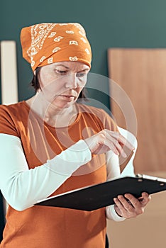 Female carpenter reading DIY project notes