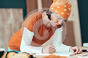Female carpenter sketching project draft notes in woodwork workshop photo