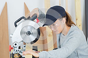 Female carpenter using circular saw