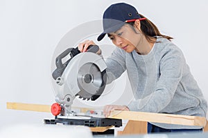 Female carpenter using circular saw