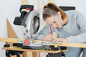 Female carpenter using circular saw