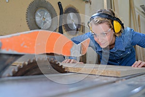 Female carpenter using circular saw