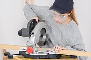 Female carpenter using circular saw