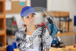 female carpenter using electric drill