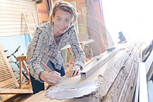 Female carpenter using electric sander for wood
