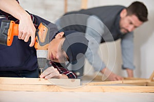 female carpenter using power screwdriver on wood