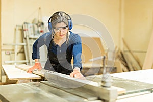 Female carpenter using a table saw photo