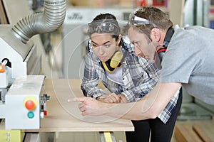 Female carpenter working with wood machine