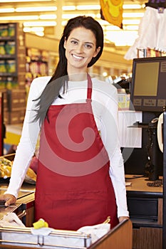 Female Cashier At Supermarket Checkout