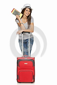 Female in casual standing with travel suitcase