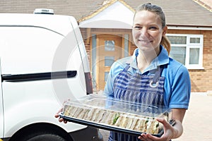 Female Caterer Delivering Tray Of Sandwiches To House