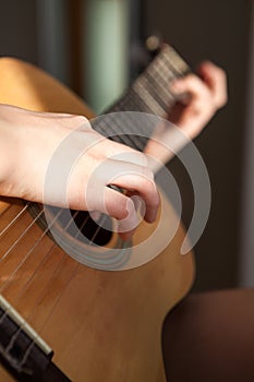 Female Caucasian arms with acoustic quitar, close up view photo