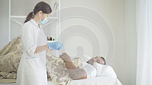 Female Caucasian doctor taking temperature of male African American patient in hospital. Professional woman in face mask