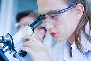 Female caucasian scientist wearing protective glasses l in laboratory photo