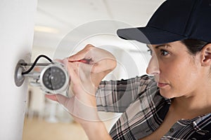 female cctv installer checking security camera