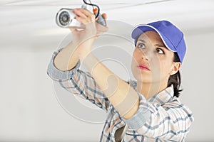 female cctv installer checking security camera