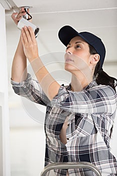 female cctv installer checking security camera