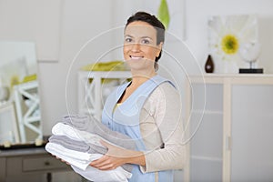 Female chambermaid holding clean white folded towels