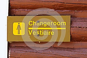 A female change room sign on painted red wood