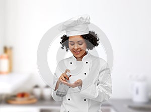 female chef applying hand sanitizer or liquid soap
